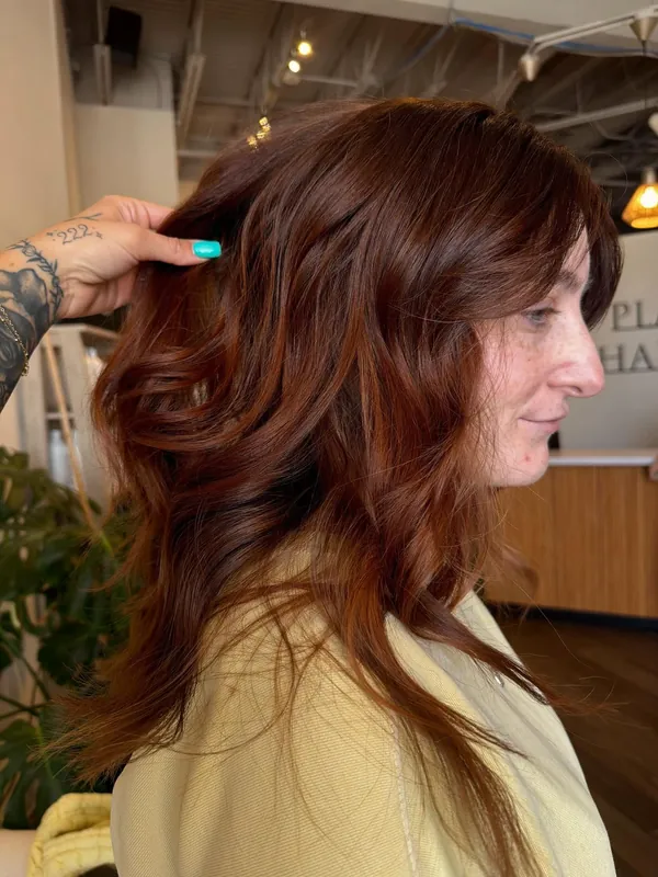 Glossy copper red hair with face-framing layers