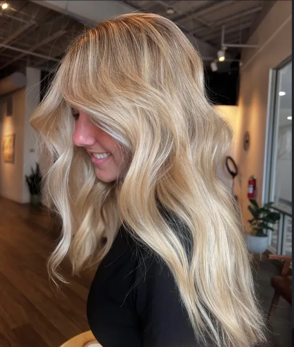 Creamy bright blonde with soft face-framing pieces and loose waves