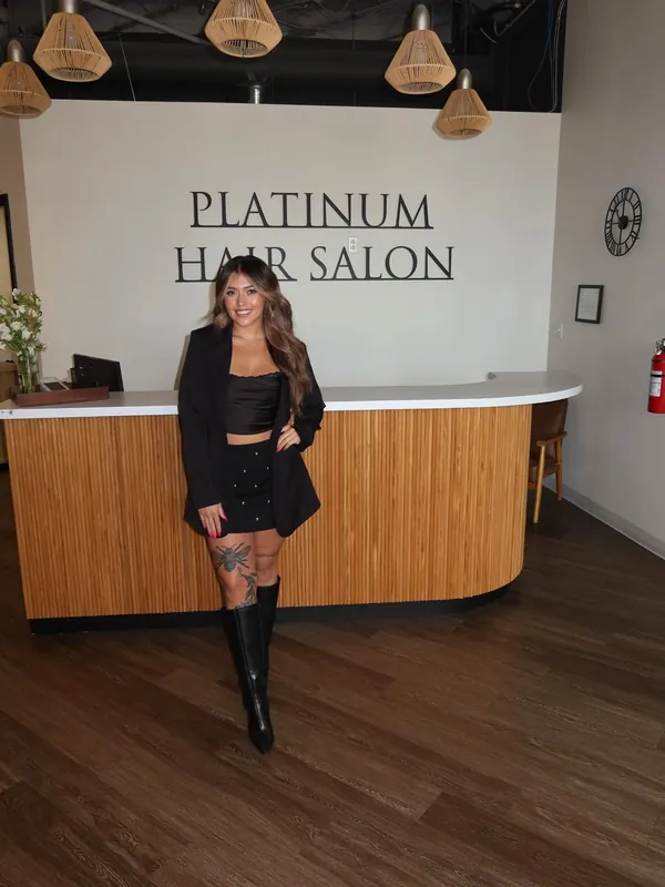 Emilee Friedrich standing in front of the Platinum Hair Salon sign