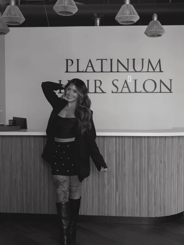 Black and white photo of Emilee Friedrich at the salon front desk